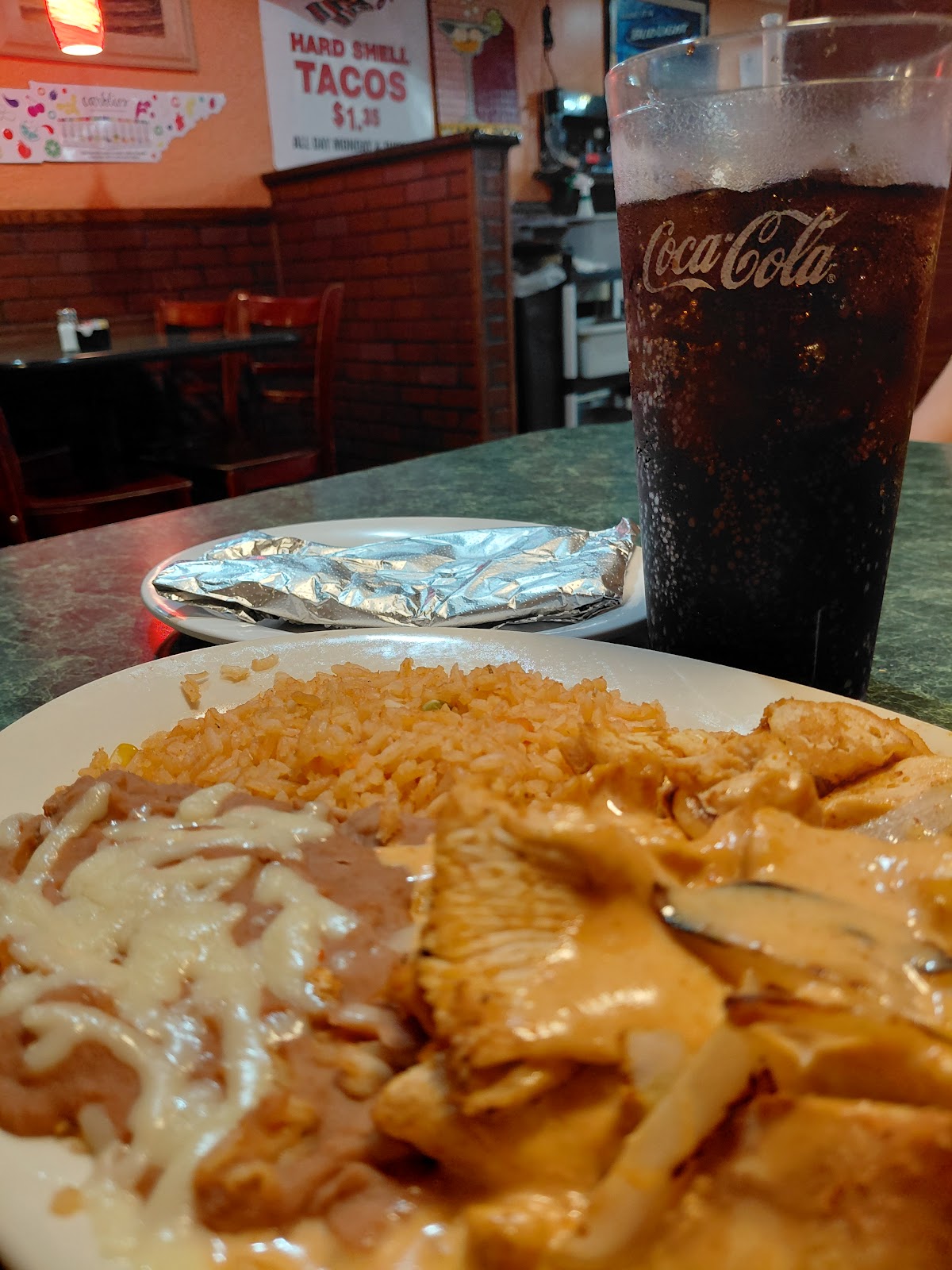 Chicken in cream sauce with rice and beans and a cold drink