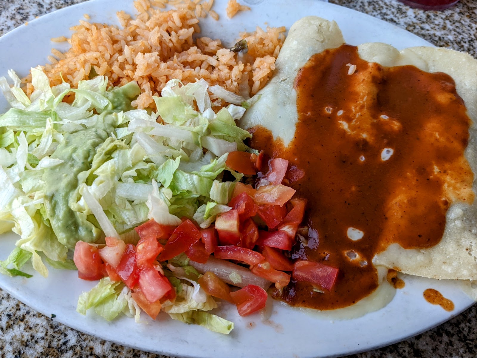 Enchiladas plate with rice, lettuce, guacamole and pico de gallo