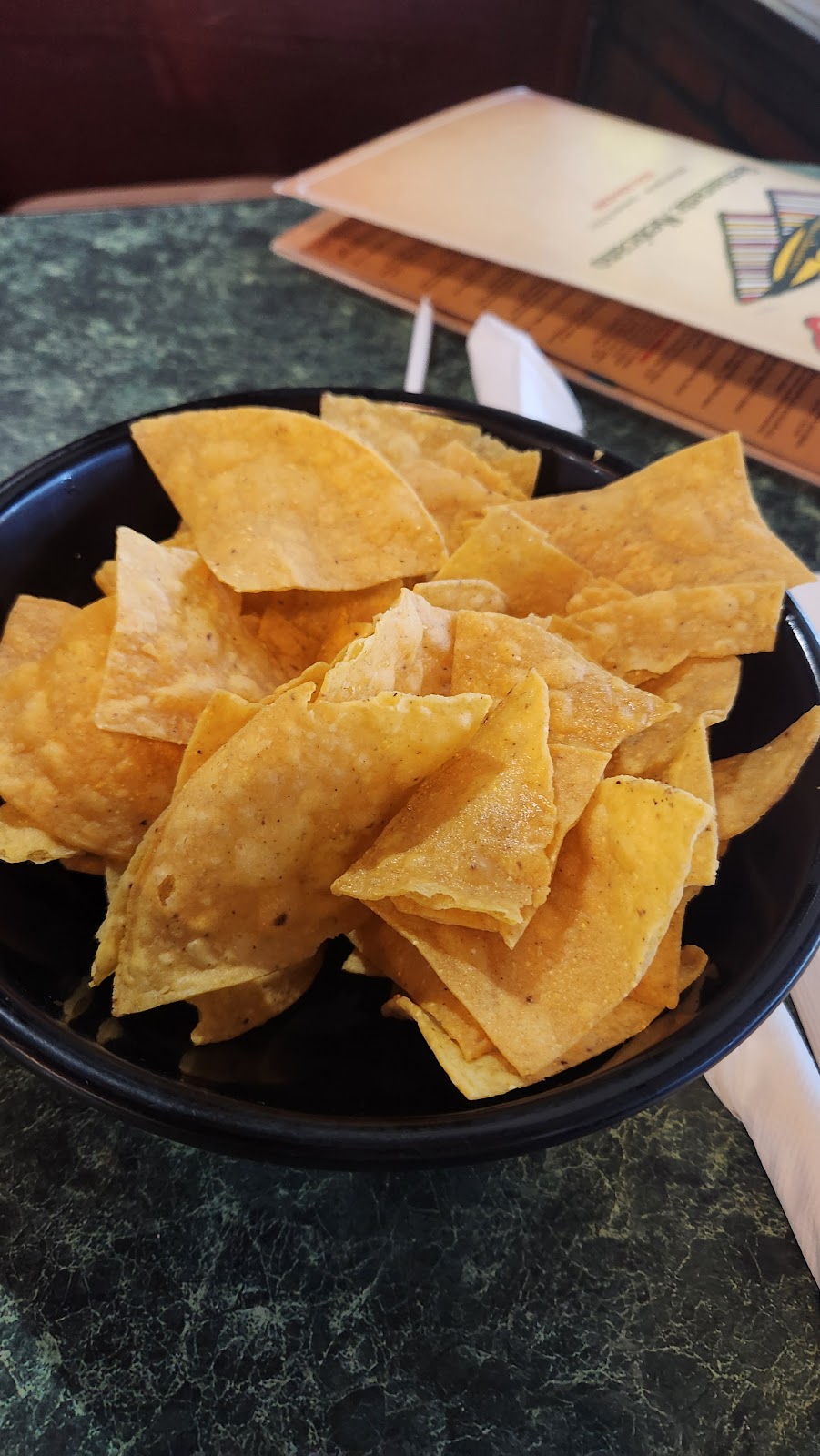 A bowl of fresh tortilla chips on the table