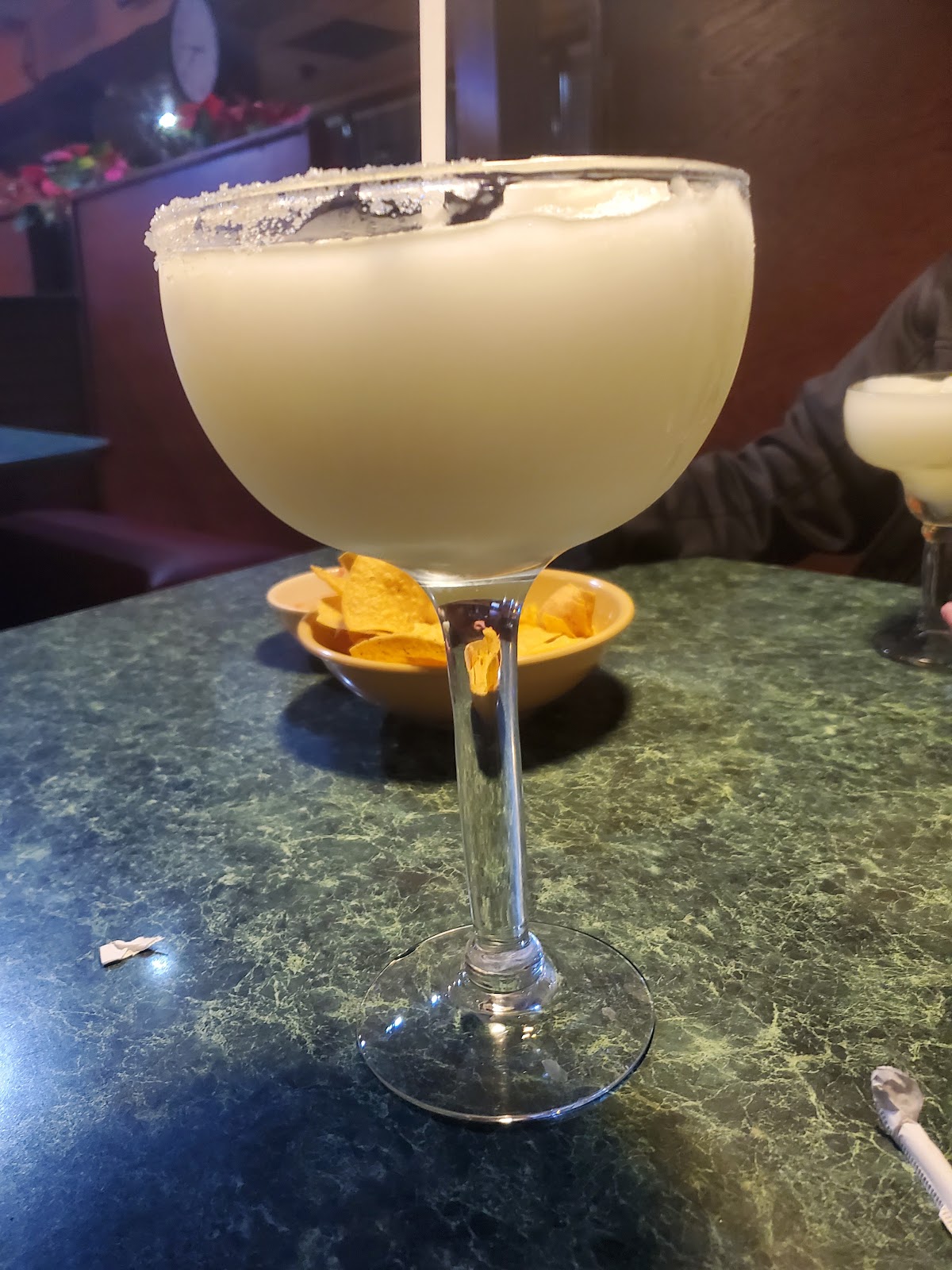 A salt-rimmed margarita on a marble cantina table